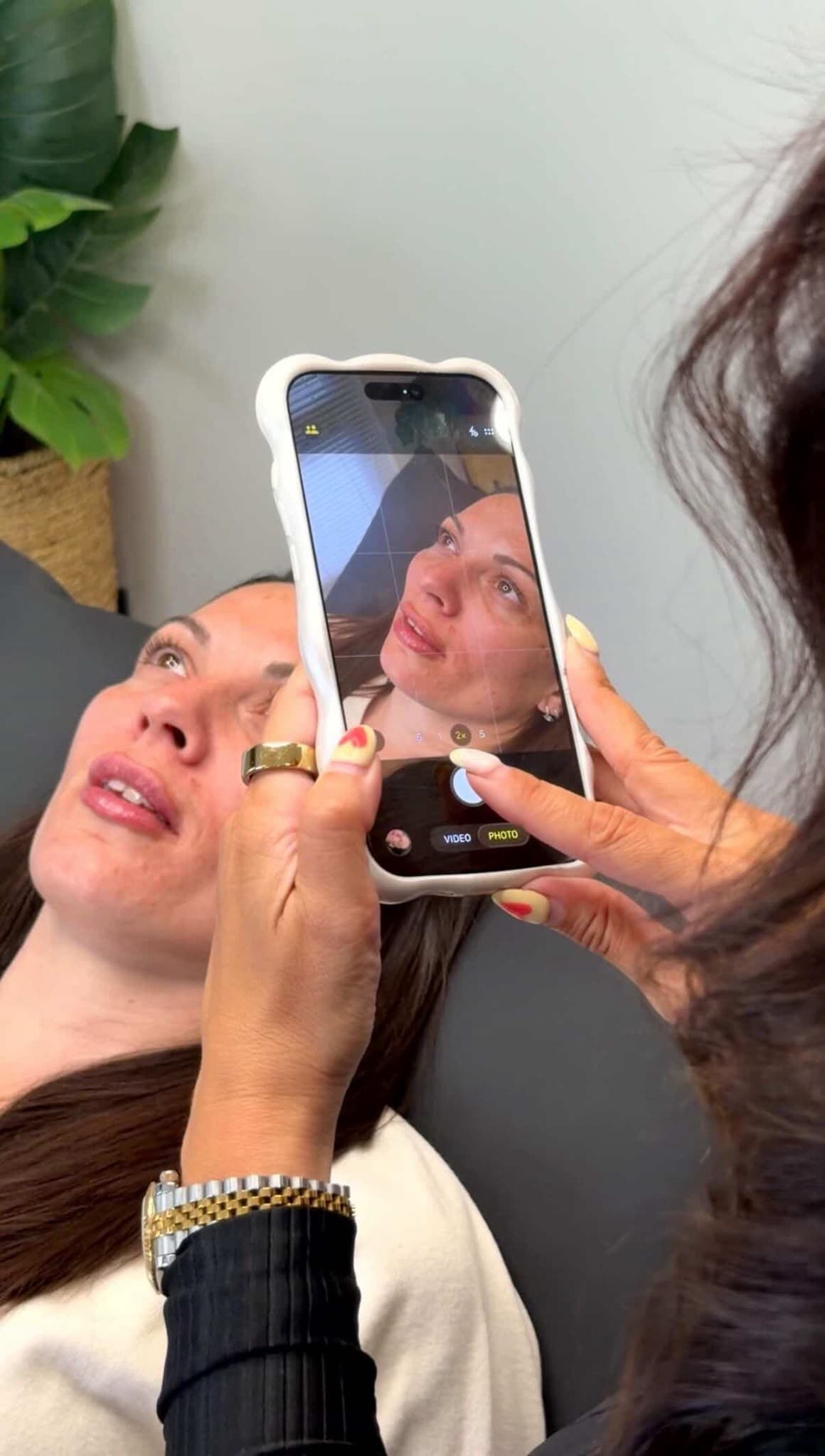 A client checking her natural, balanced lip filler result after treatment with Safina